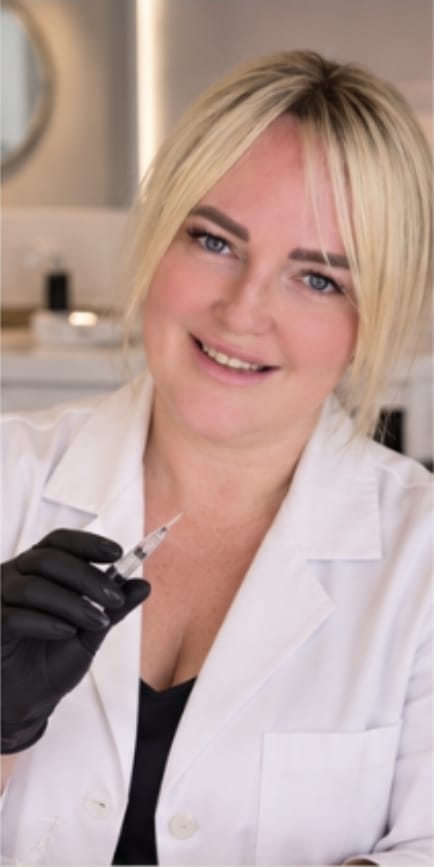 Practitioner in a white coat holding a syringe at Aesthetics by D in East Kilbride